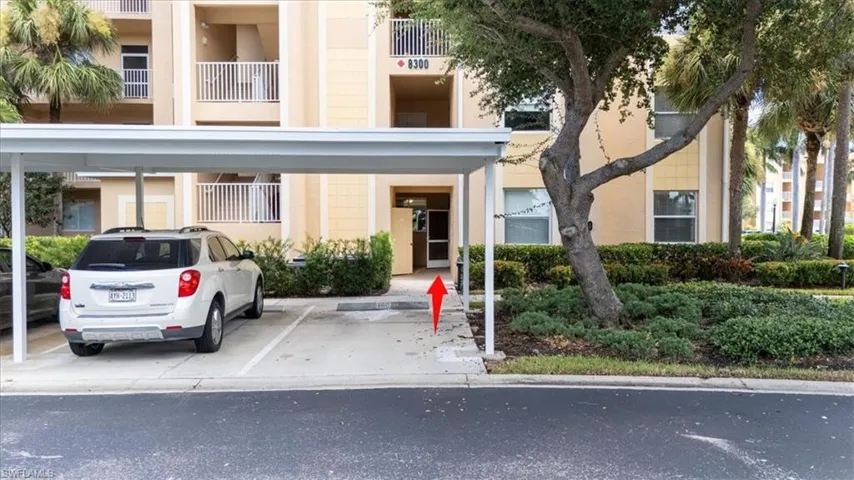 View of apartment building / complex with covered parking
