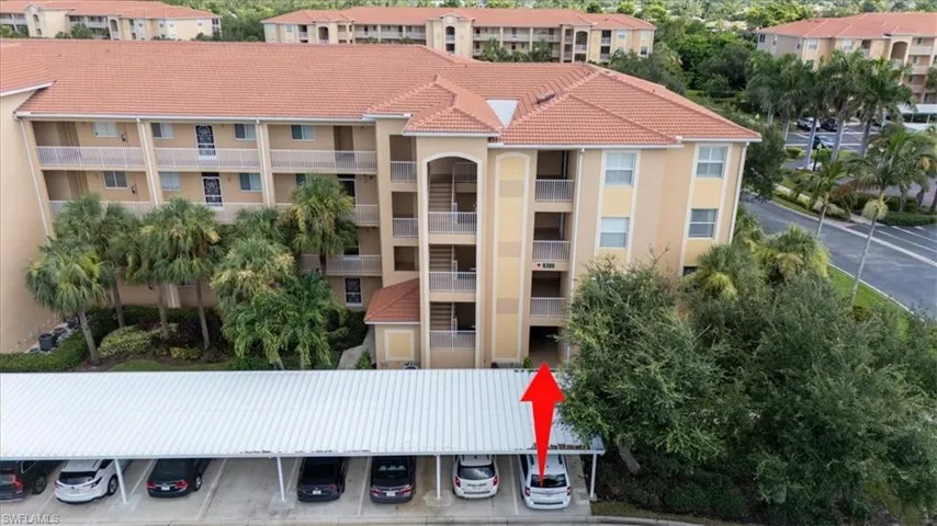 View of apartment building / complex with covered parking