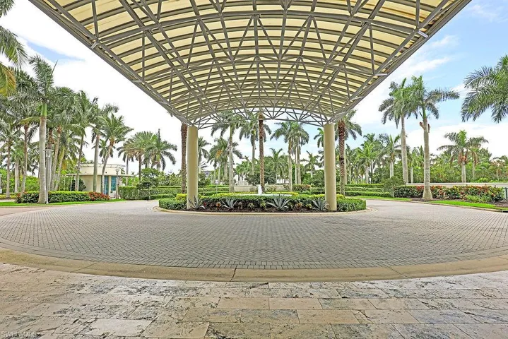 Canopy-covered entryway featuring a circular paver driveway