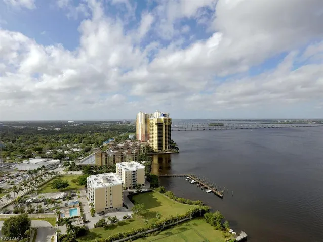 Aerial perspective featuring a multi-story building complex with waterfront access