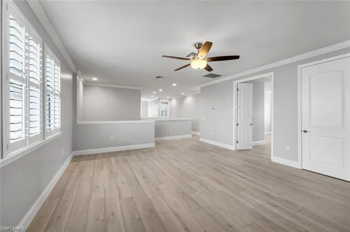 Unfurnished living room with ceiling fan, light wood-type flooring, ornamental molding, and recessed lighting
