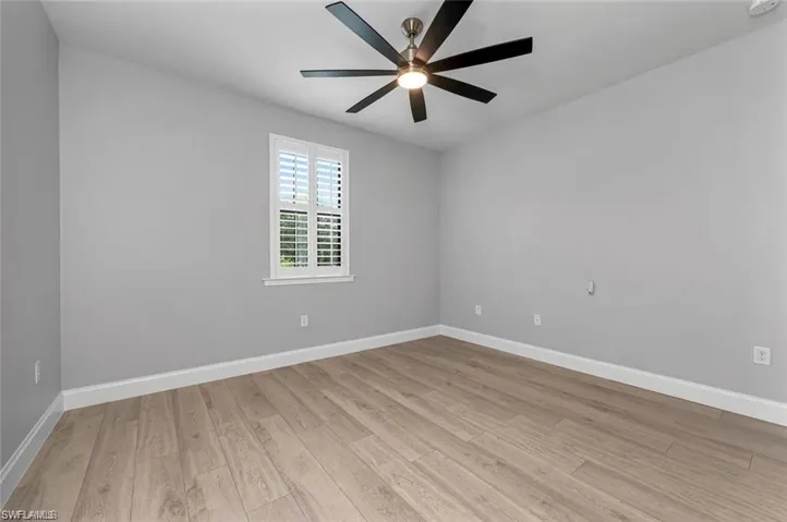 Empty room featuring light wood-style flooring and a ceiling fan