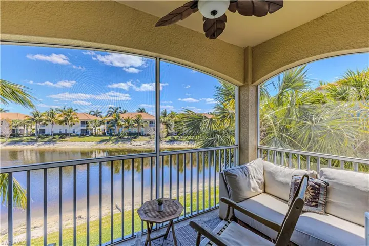 Screened in patio featuring plenty of natural light, a ceiling fan, and a water view