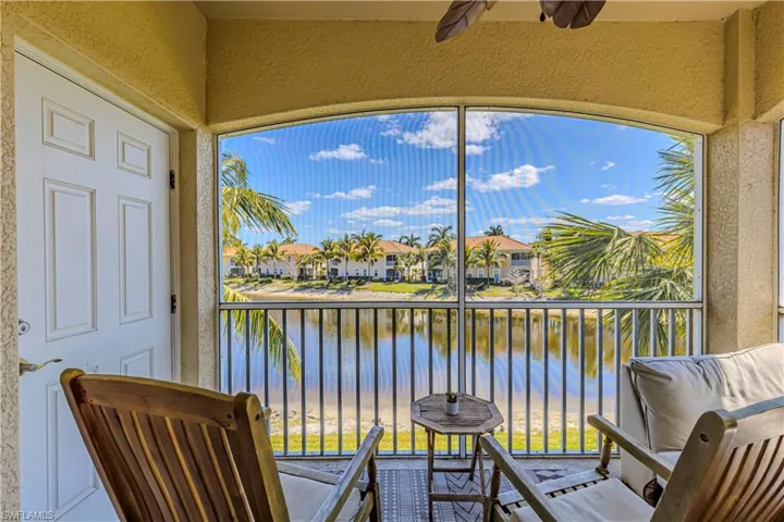 Screened in patio with water view, ceiling fan, and storage