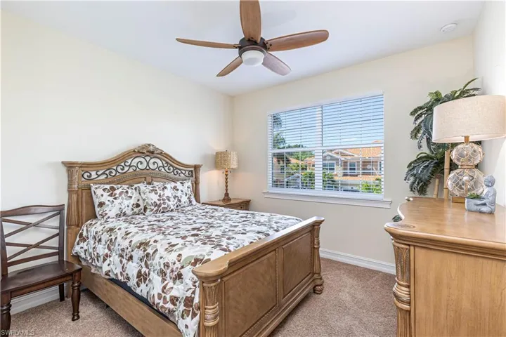 Second bedroom featuring baseboards, light colored carpet, and ceiling fan