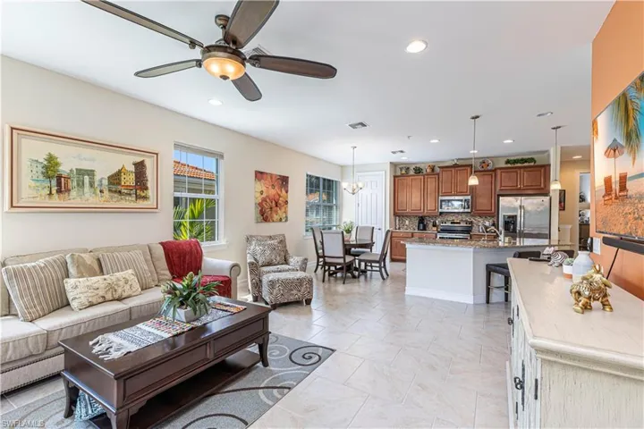 Living room featuring recessed lighting, ceiling fan with notable chandelier, and visible vents