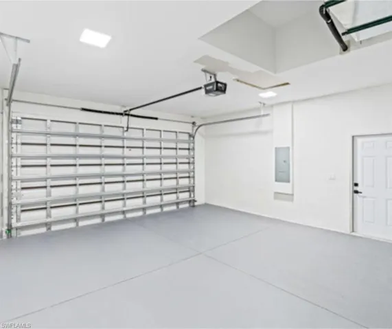 Garage with electric panel and a garage door opener