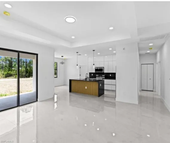 Kitchen featuring open floor plan, pendant lighting, a spacious island, recessed lighting, and stainless steel microwave