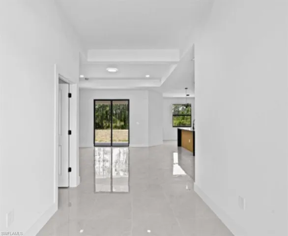 Empty room with a raised ceiling and healthy amount of natural light