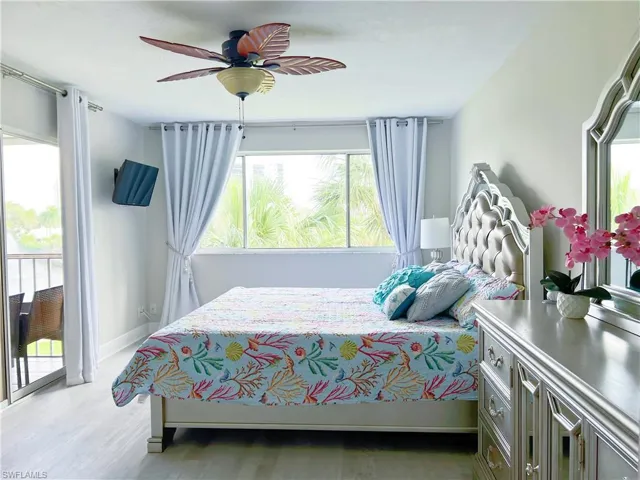 Bedroom featuring access to outside, light wood-style floors, and a ceiling fan