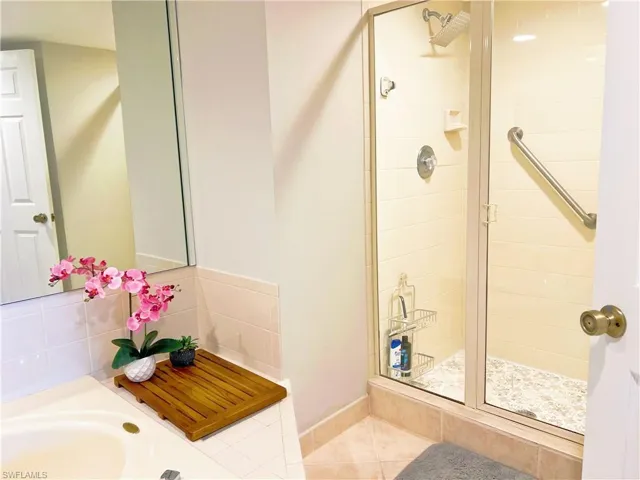 Bathroom with a stall shower and tile patterned floors