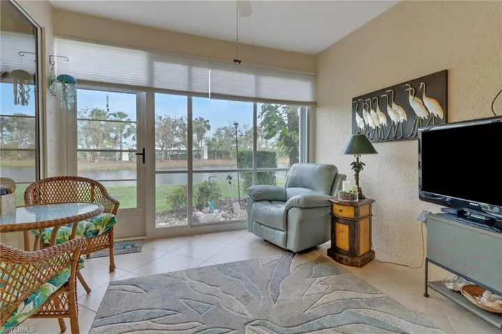 Living room with light tile patterned floors, a textured wall, and ceiling fan