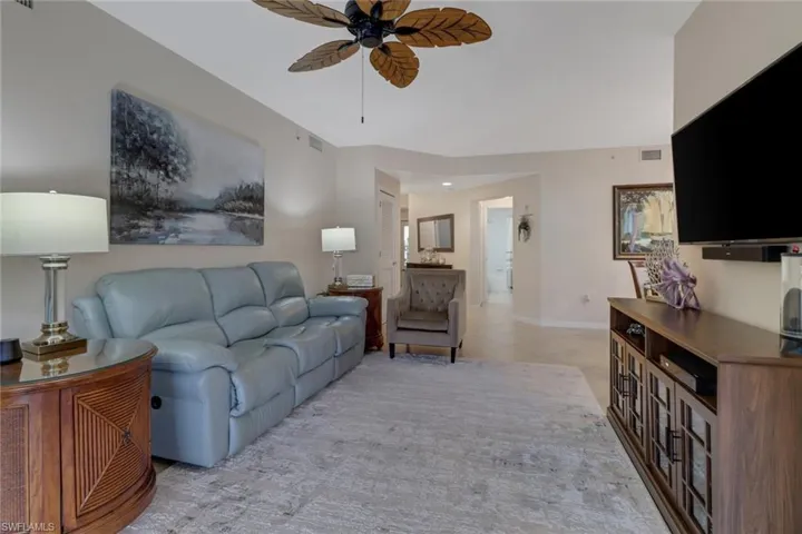 Living area featuring ceiling fan and baseboards