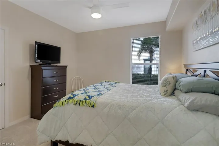 Bedroom featuring a ceiling fan and light colored carpet
