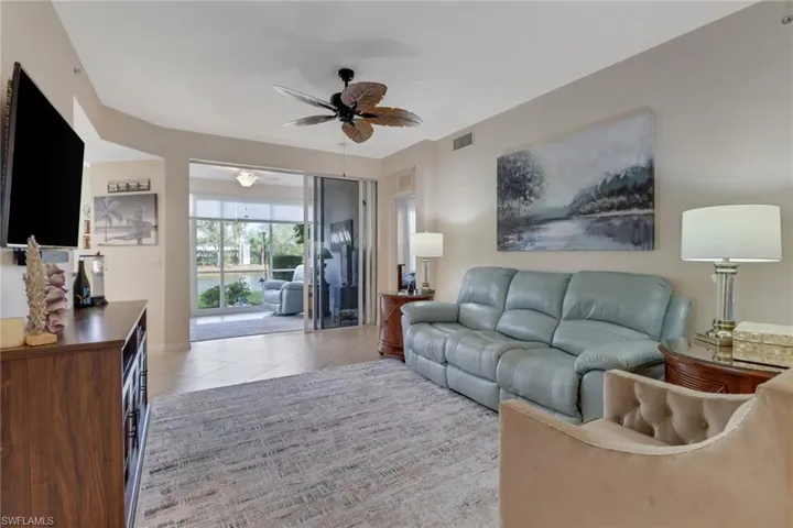 Living room with a ceiling fan and light tile patterned floors