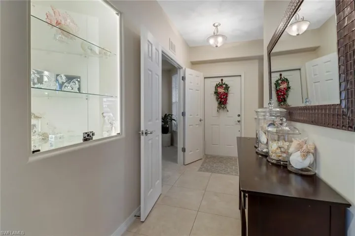 Foyer entrance with light tile patterned floors and baseboards