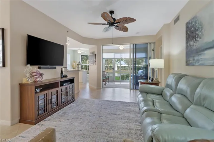 Living room featuring light tile patterned floors and ceiling fan