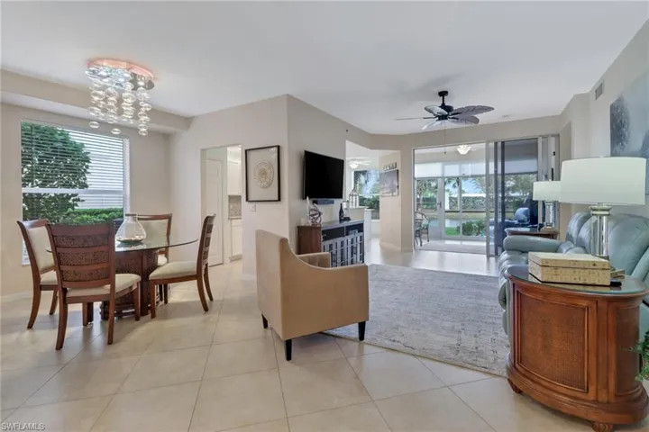 Living room with a ceiling fan, light tile patterned floors, healthy amount of natural light, and hanging lights