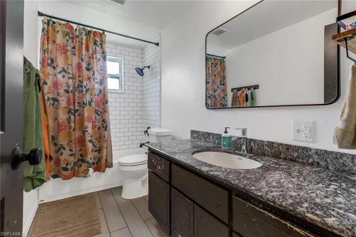 Full bathroom with vanity, toilet, and shower / bath combo