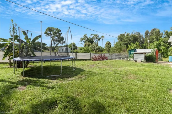 View of yard with a storage unit and a trampoline