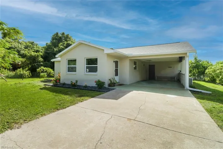 Ranch-style house featuring a carport and a front yard