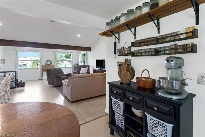 Living room with lofted ceiling and light tile patterned flooring