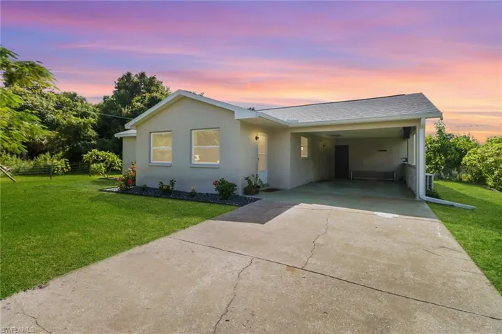 Single story home with a yard and a carport