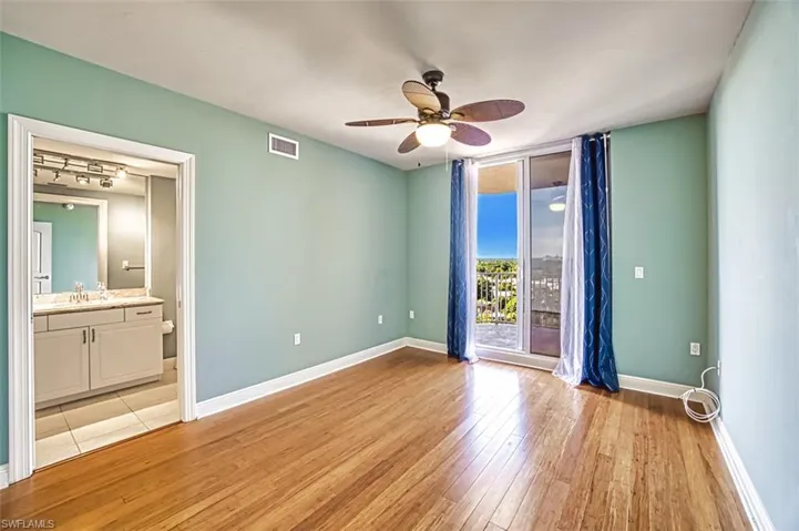 Spare room featuring a ceiling fan, light wood finished floors, and a wall of windows