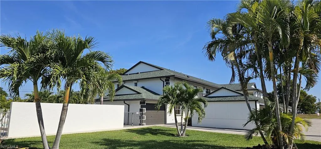 View of front of home featuring a shingled roof, stucco siding, and a garage