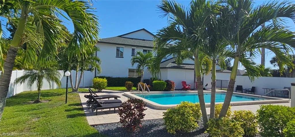 Community pool with a fenced backyard and a patio
