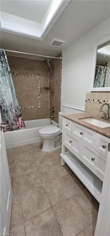 Full bath featuring vanity and shower / bathtub combination with curtain