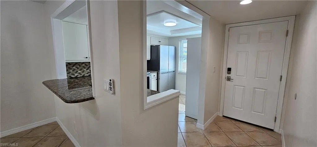 Corridor with light tile patterned flooring