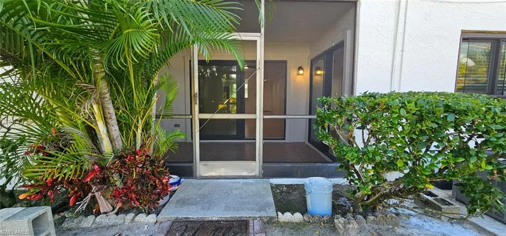 Doorway to property featuring a sunroom and stucco siding
