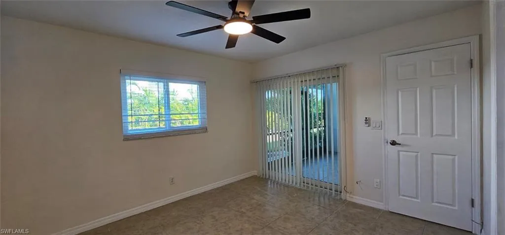Owners Suite with plenty of natural light, ceiling fan, and light tile patterned flooring