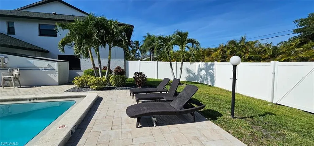 Fenced backyard featuring a patio area and a community pool