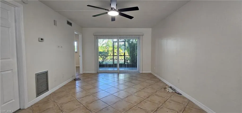 Living room with light tile patterned flooring and a ceiling fan