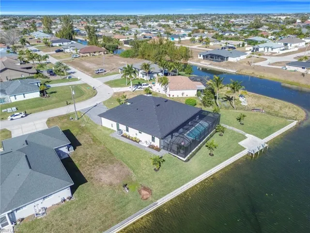 Aerial view of property and surrounding area with nearby suburban area and a large body of water