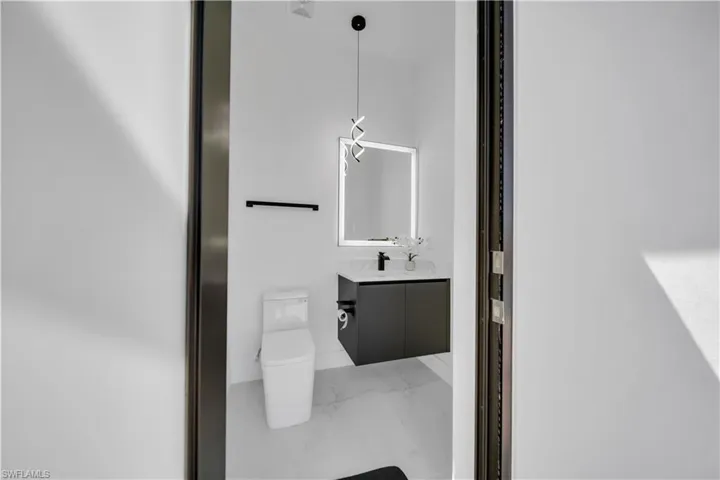 Half bathroom featuring vanity and light marble finish floors
