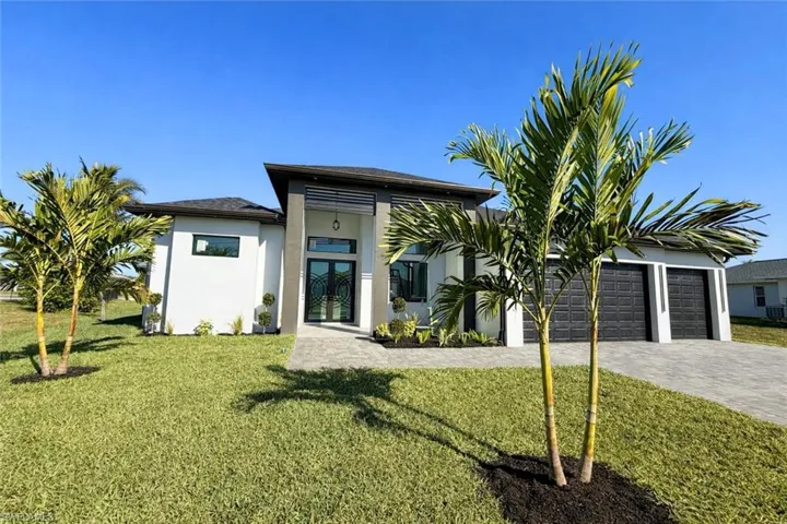 View of front of house with stucco siding, a front lawn, and french doors