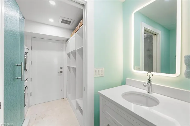 Additional bathroom with a stackable washer/ dryer