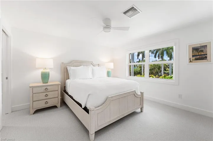 Spacious guest bedroom with natural light and coastal charm.