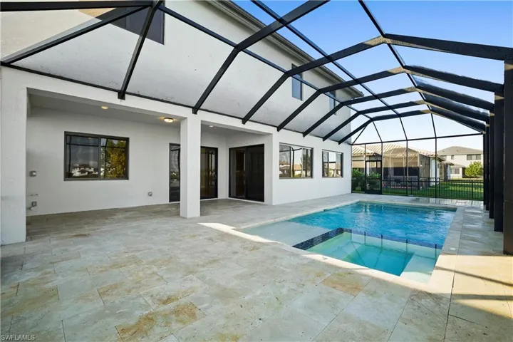 Lakefront heated saltwater pool and spa with travertine decking