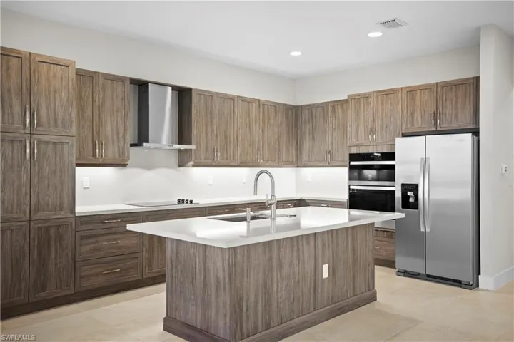 Kitchen detail with wall-mounted hood and quartz slab backsplash