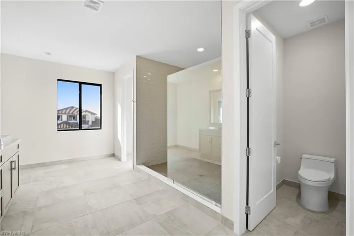 Primary suite oversized walk-in closet with custom shelving