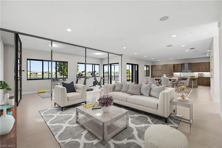 Virtually staged to illustrate how the open living area can be thoughtfully styled, including a dedicated fitness zone while maintaining a seamless flow for everyday living and entertaining.