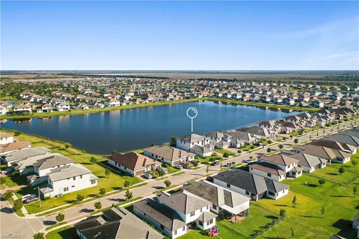 Aerial view of the subject home centered in Maple Ridge with lake behind
