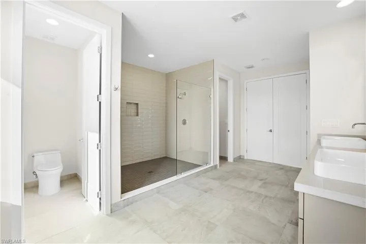 Alternate view of the primary bathroom showcasing dual water closets