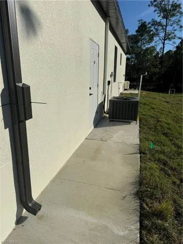 View of property exterior featuring a yard and cooling unit
