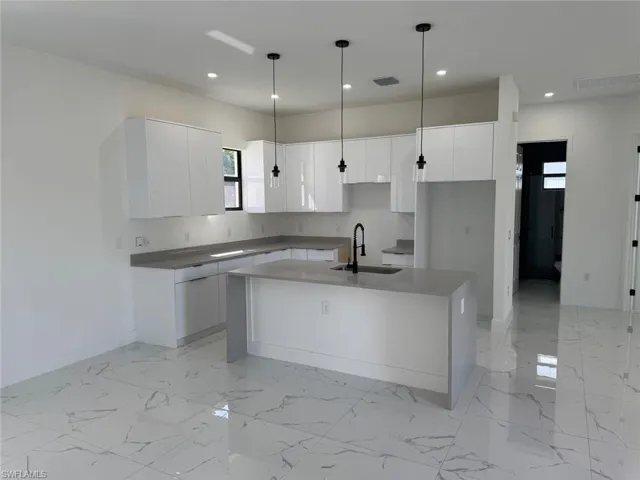 Kitchen with recessed lighting, visible vents, marble finish floor, and a sink