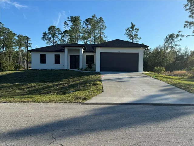 View of front of property featuring a garage and a front lawn